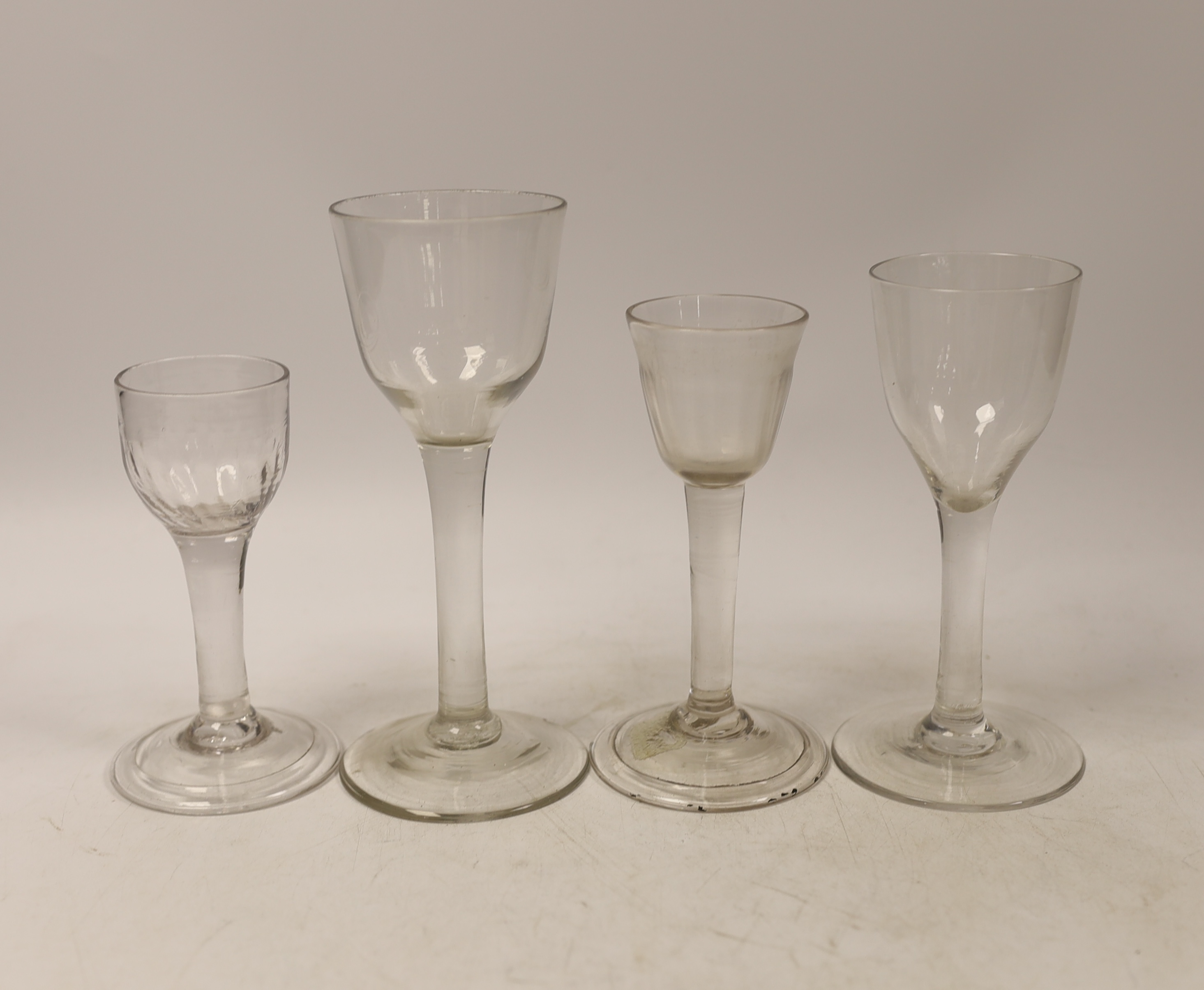 Four plain stem wine and cordial glasses, first half 18th century, two examples with folded feet, tallest 16.5cm